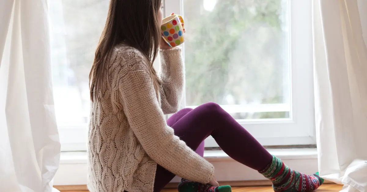 Woman sitting next to Picture Windows  in Living room at Energy Efficient Windows Australia